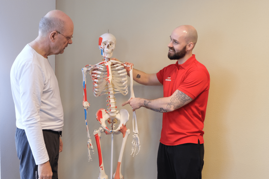 Wim krijgt uitleg over zijn rugklachten tijdens de kennismaking met Personal Trainer Tommy.